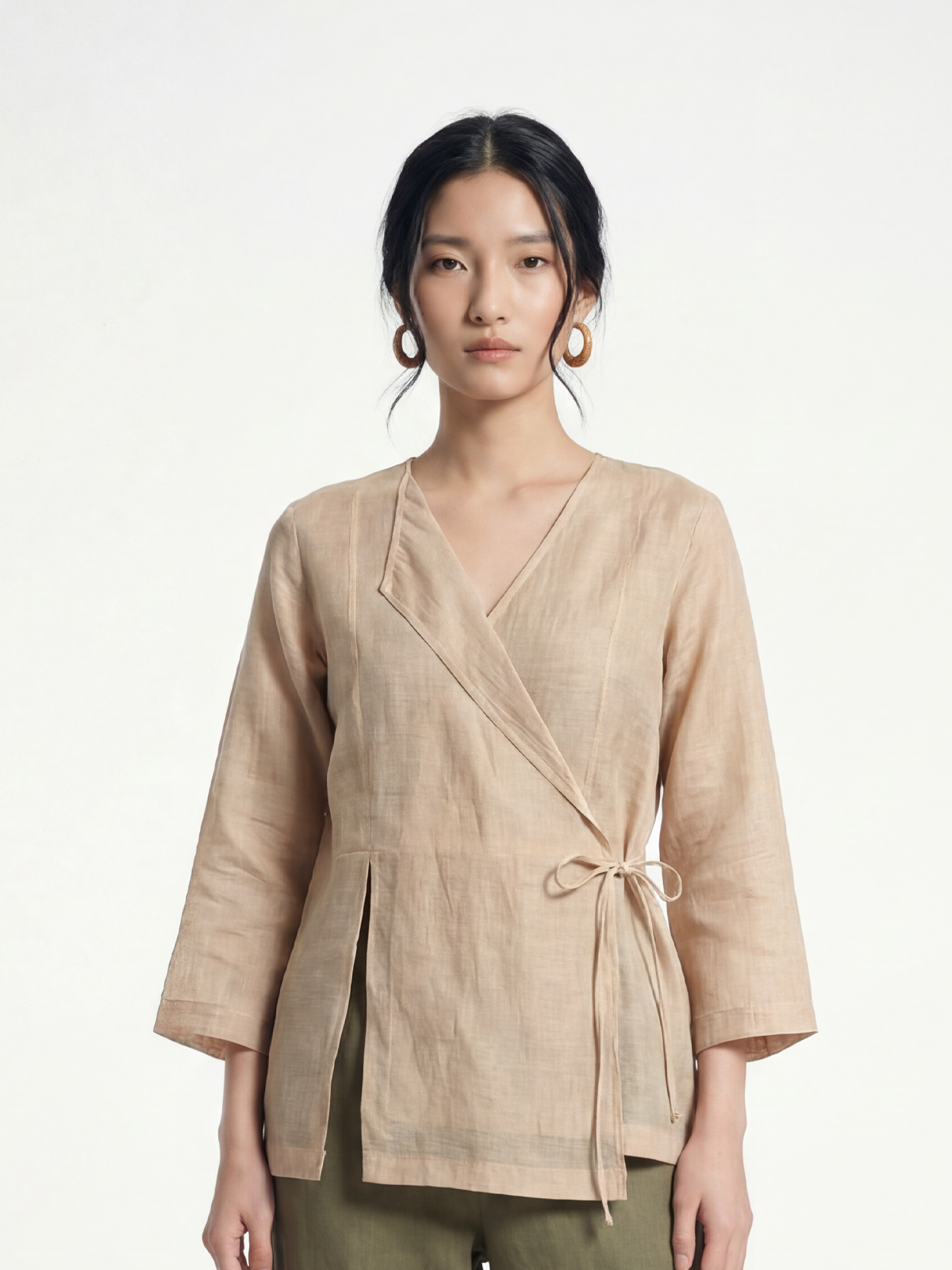 Female model wearing VUNN Sand Linen Wrap Top — sand-coloured linen wrap with V-neckline, side-tie closure and three-quarter sleeves
