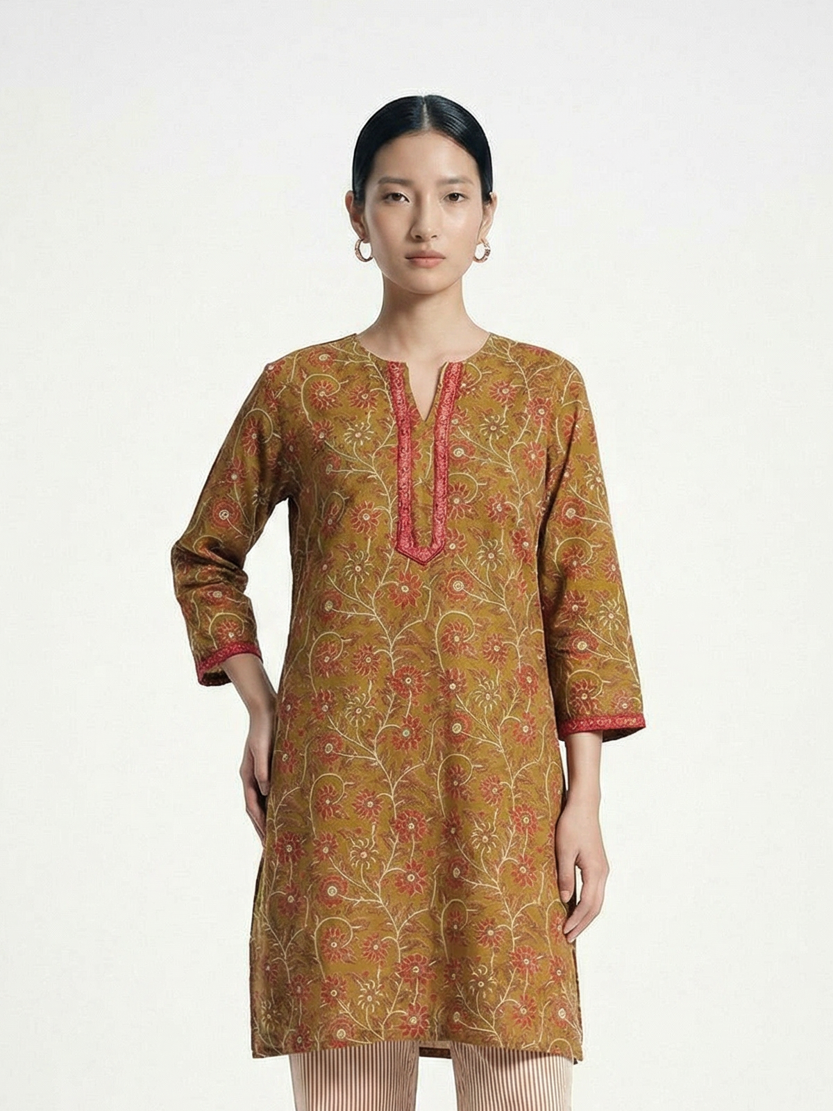 Female model wearing VUNN Taruja Kurta — mustard ochre hand-block printed cotton kurta with coral floral jaal, pink gota-lace V-neckline and mirror sequin sleeve detail