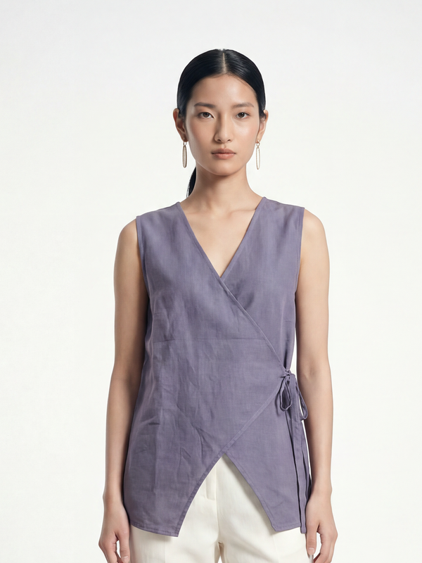 Female model wearing VUNN Dusk Linen Wrap Vest — dusty lilac-grey sleeveless linen wrap vest with a V-neckline, side-tie closure and asymmetric hem